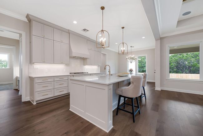 Kitchen featuring a chandelier, crown molding, light countertops, tasteful backsplash, and dark wood-type flooring | Image 14