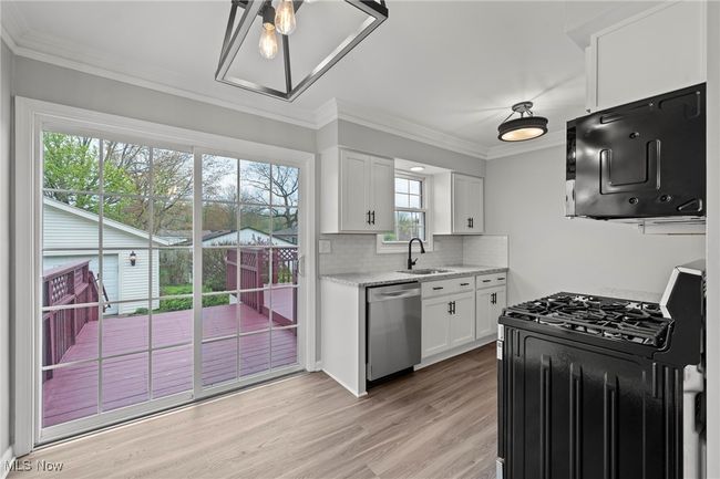 Kitchen featuring white cabinets, a sink, range with gas cooktop, light wood-type flooring, and dishwasher | Image 17