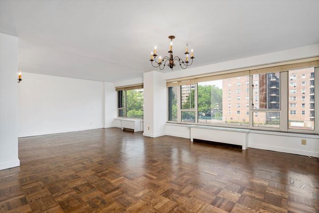 Unfurnished living room with a chandelier and baseboards | Image 6