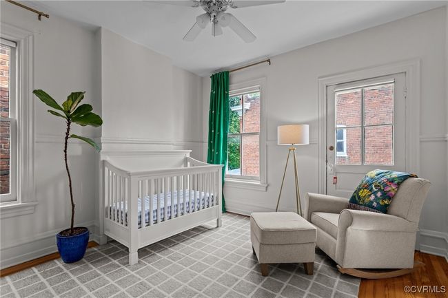 Bedroom with ceiling fan, wood finished floors, and a crib | Image 28