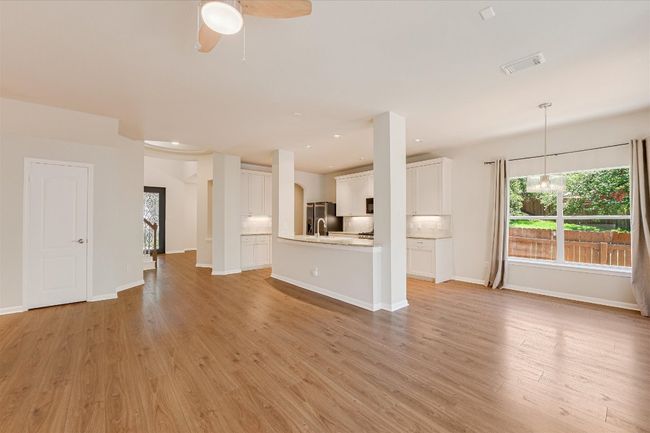Unfurnished living room featuring light wood-style flooring, ceiling fan, recessed lighting, and a chandelier | Image 4