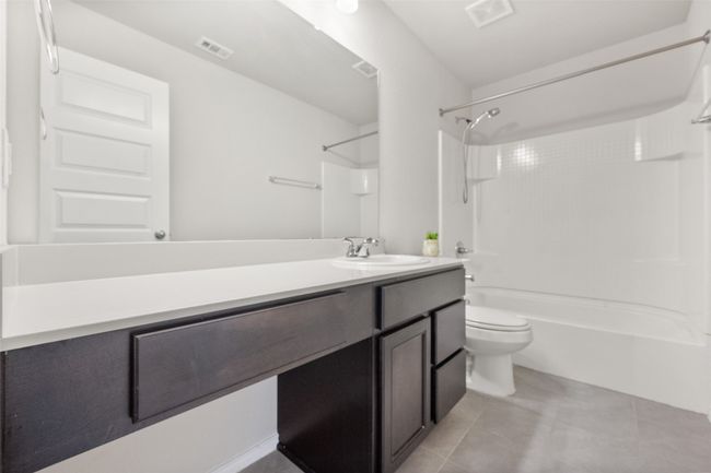 upstairs Full bath with toilet, vanity, tile patterned flooring, visible vents, and shower / bath combination | Image 17