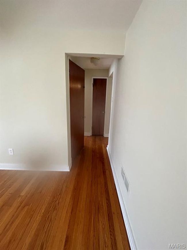 Hallway featuring baseboards, wood finished floors, and visible vents | Image 13