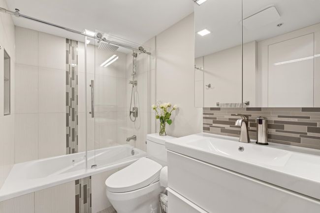Bathroom with shower / bath combination with glass door, toilet, vanity, and backsplash | Image 29
