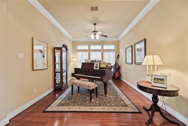 Formal Living Room with polished wood floors and crown molding offers the perfect space for interesting conversations, reading a book, or pursuing your artistic passion. | Image 6