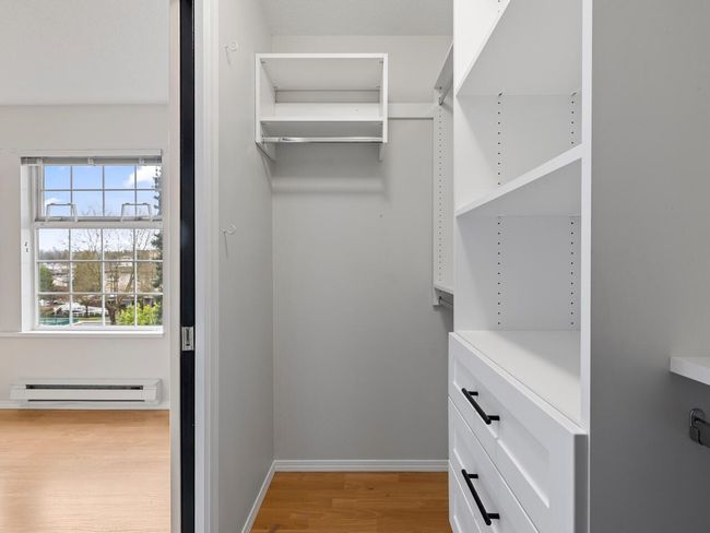 Walk in closet with light wood finished floors and a baseboard radiator | Image 13