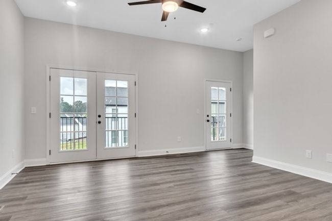 Check out the gorgeous wall of doors that fill the living area with light even without turning on the inside lighting. An expansive deck runs the length of the living area and would be perfect to entertain guests and grow favorite flowers & herbs. | Image 17