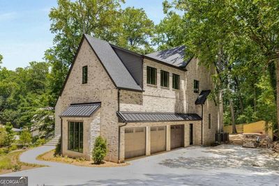 Garage - Long driveway, plenty of guest parking and a 3-car garage with additional storage room and super high ceilings! | Image 3