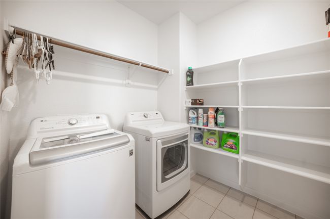 Laundry area featuring separate washer and dryer and light tile patterned floors | Image 14