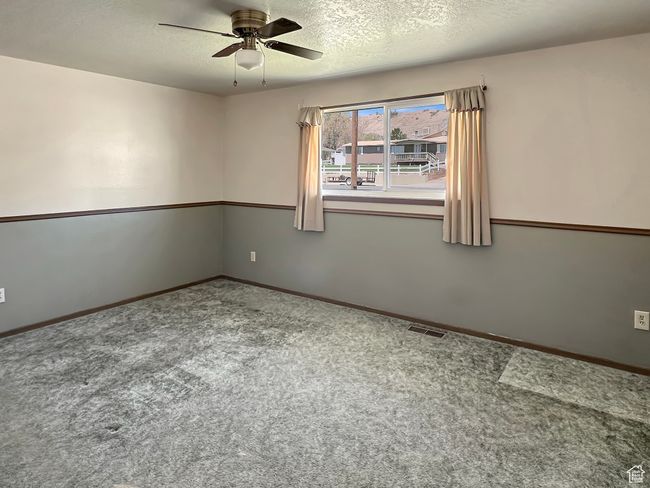 Unfurnished room with ceiling fan, carpet floors, a textured ceiling, and baseboards | Image 18