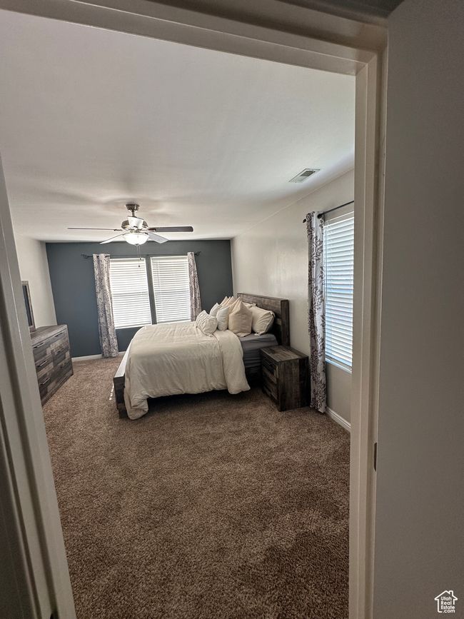 Bedroom featuring carpet, visible vents, and multiple windows | Image 15