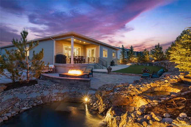 Custom landscaping with professional lighting, Belgard paver entertaining area, pond w/waterfalls, built-in 72" fireplace with seating bench, sports area, storage shed, mature trees and additional gas lines for whatever your heart desires | Image 4