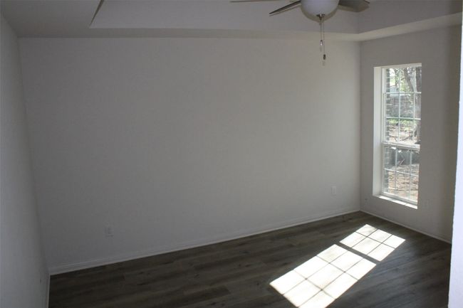 Empty room featuring ceiling fan and dark wood-type flooring | Image 11