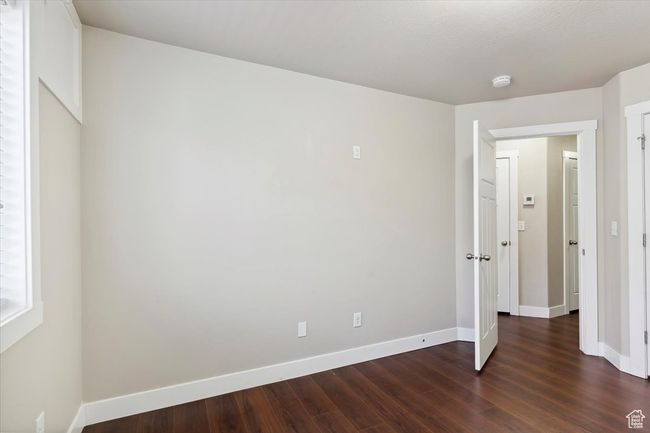 Unfurnished bedroom featuring dark wood finished floors and baseboards | Image 25