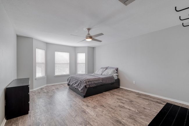Bedroom with wood finished floors and ceiling fan | Image 26
