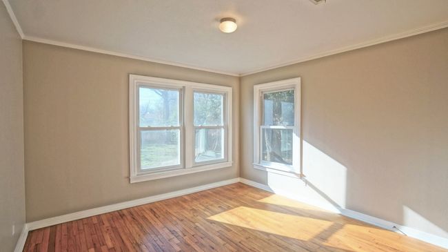 Empty room with plenty of natural light, wood finished floors, and ornamental molding | Image 6