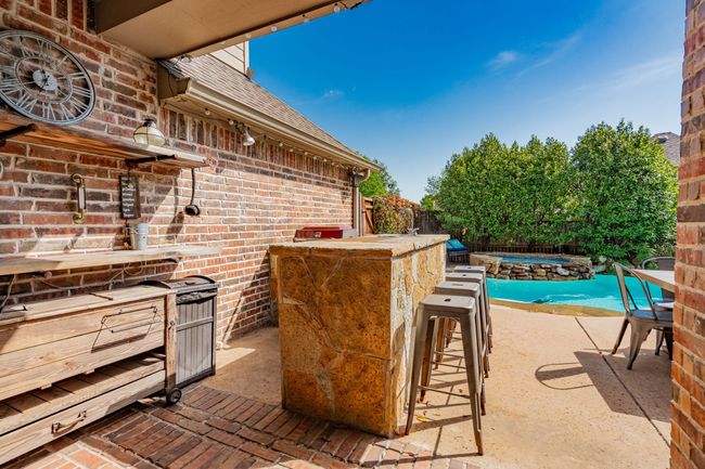 View of patio with an outdoor pool, a fenced backyard, and a hot tub | Image 31