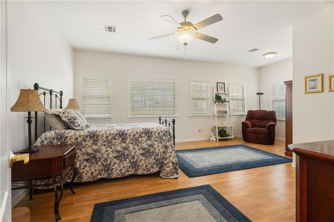Bedroom featuring visible vents, baseboards, a ceiling fan, and wood finished floors | Image 17