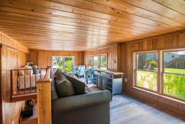 Living room featuring wooden ceiling and wood walls | Image 13