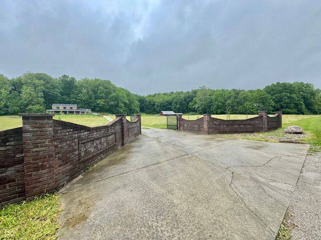 view of patio / terrace with a view of trees, a gate, and driveway | Image 16