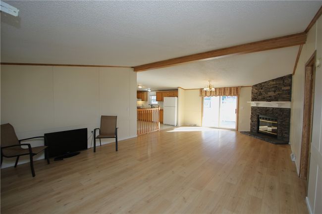 Front Entry into 16x26 Great Room boasting a Stacked-Stone Gas Fireplace w/ Wood Mantel | Image 5