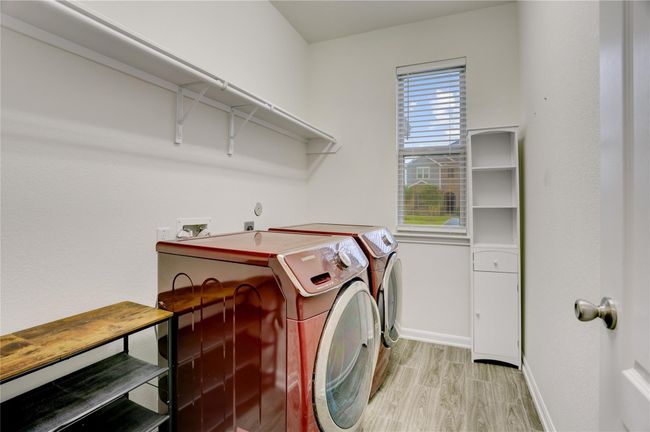 The large laundry room is downstairs and features ample storage and hanging space. | Image 12