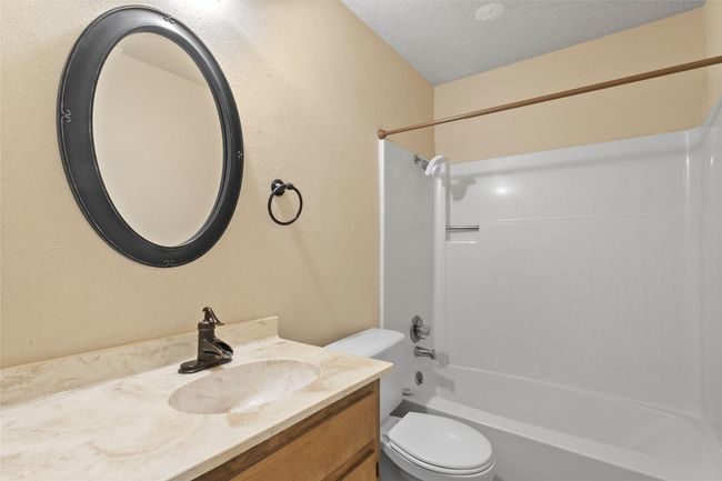 Bathroom with vanity, a textured ceiling, and shower / washtub combination | Image 20
