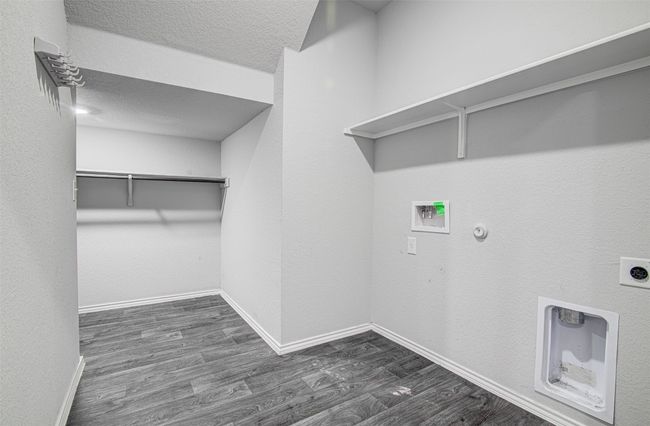 Laundry room with dark wood-style flooring, hookup for a gas dryer, laundry area, hookup for an electric dryer, and hookup for a washing machine | Image 7
