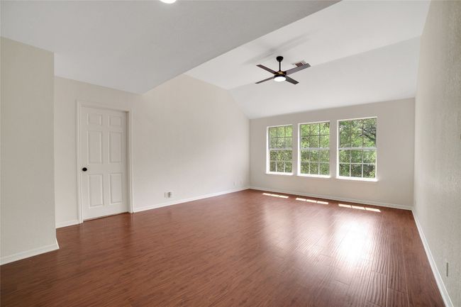 Spare room with baseboards, ceiling fan, vaulted ceiling, and dark wood-style flooring | Image 22