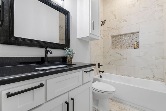 Secondary bath featuring vanity, toilet, marble finish floor, and shower / bathtub combination | Image 23