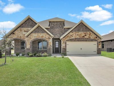 Mediterranean / spanish-style house featuring a garage, a front yard, and central AC unit | Image 2