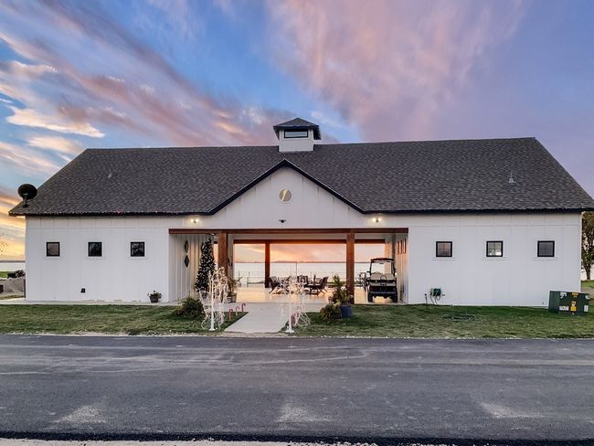 Back of house at dusk featuring a yard, board and batten siding, and roof with shingles | Image 12