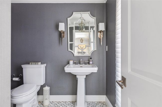 Half bathroom featuring wallpapered walls, toilet, baseboards, and a sink | Image 7