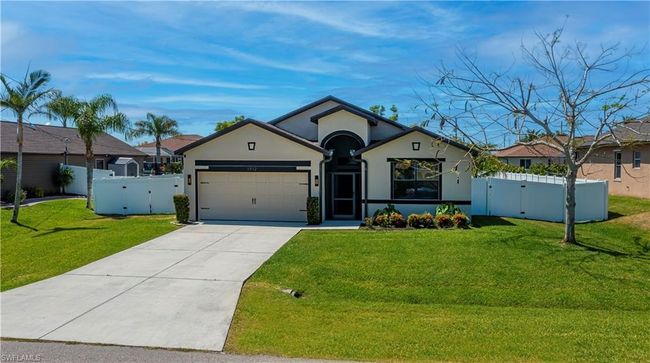 Ranch-style house with a garage, a gate, stucco siding, and fence | Image 34