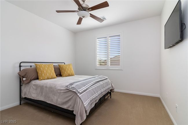 Carpeted bedroom featuring baseboards, visible vents, and ceiling fan | Image 31
