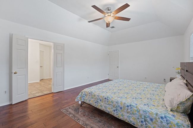 Bedroom with hardwood / wood-style flooring, a ceiling fan, and vaulted ceiling | Image 19