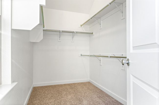 Walk in closet featuring light carpet | Image 32