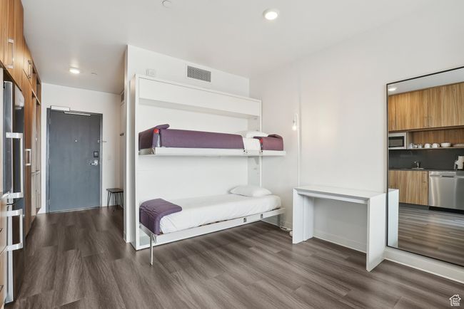 Bedroom with wood finished floors, recessed lighting, visible vents, and a sink | Image 10