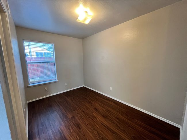 This is a view of a bedroom. Notice the beautiful flooring and the natural lighting coming from the window. | Image 6