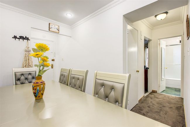 Carpeted dining space with ornamental molding and baseboards | Image 15