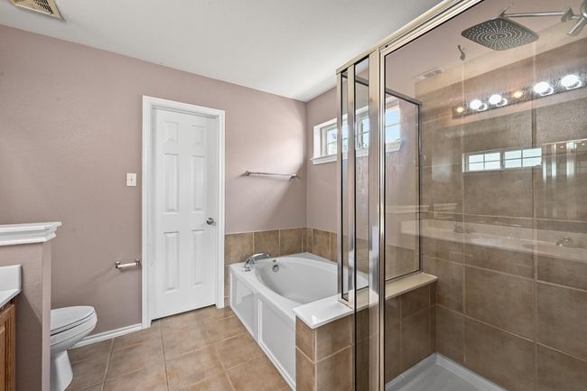 Full bathroom featuring a stall shower, a garden tub, vanity, and tile patterned flooring | Image 22