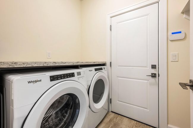 Laundry room with laundry area, separate washer and dryer, and light wood finished floors | Image 30