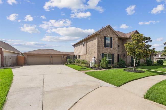 Long, wide driveway with 3 car garage. Plenty of space for parking. The garage has built-in cabinets. | Image 41