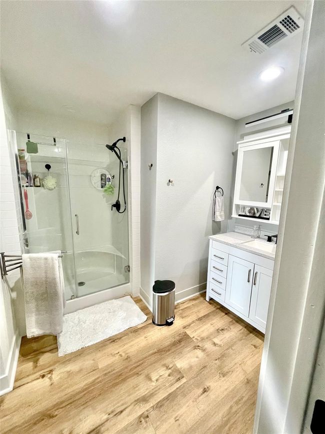 Full bath with a shower stall, vanity, and wood finished floors | Image 12