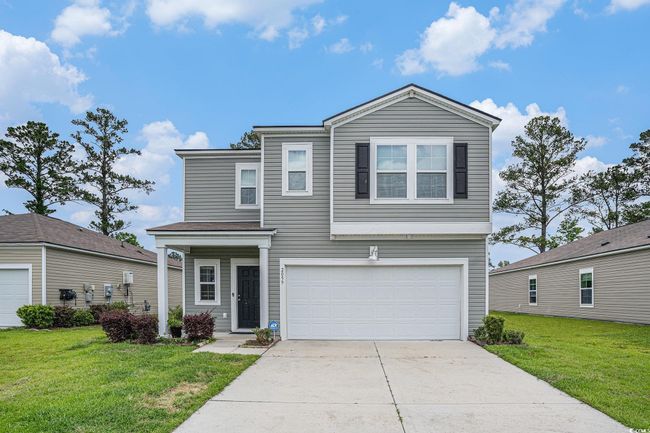 Traditional-style house with a garage, concrete driveway, and a front lawn | Image 8