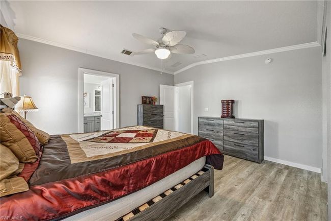 Bedroom featuring light wood-style flooring, ornamental molding, ceiling fan, baseboards, and visible vents | Image 24