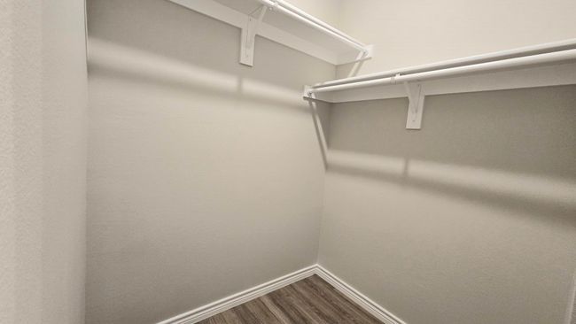 Spacious closet with dark wood-style flooring | Image 15