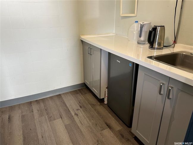 Kitchen with dark wood-style floors, gray cabinets, light countertops, and dishwashing machine | Image 19