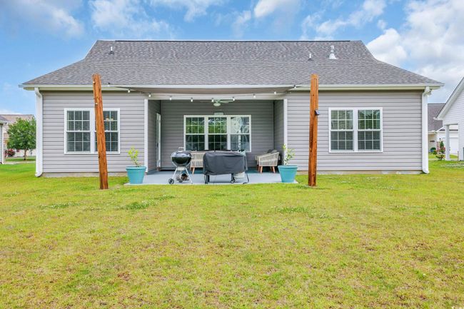 Rear view of house featuring a patio area, a shingled roof, a yard, and ceiling fan | Image 39