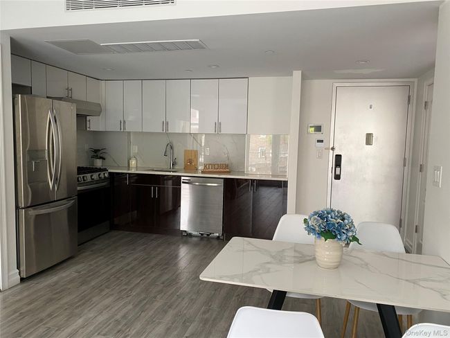 Kitchen with white cabinets, stainless steel appliances, modern cabinets, and backsplash | Image 8